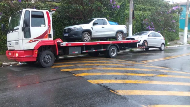 Guincho plataforma em atendimento a uma picape e um carro